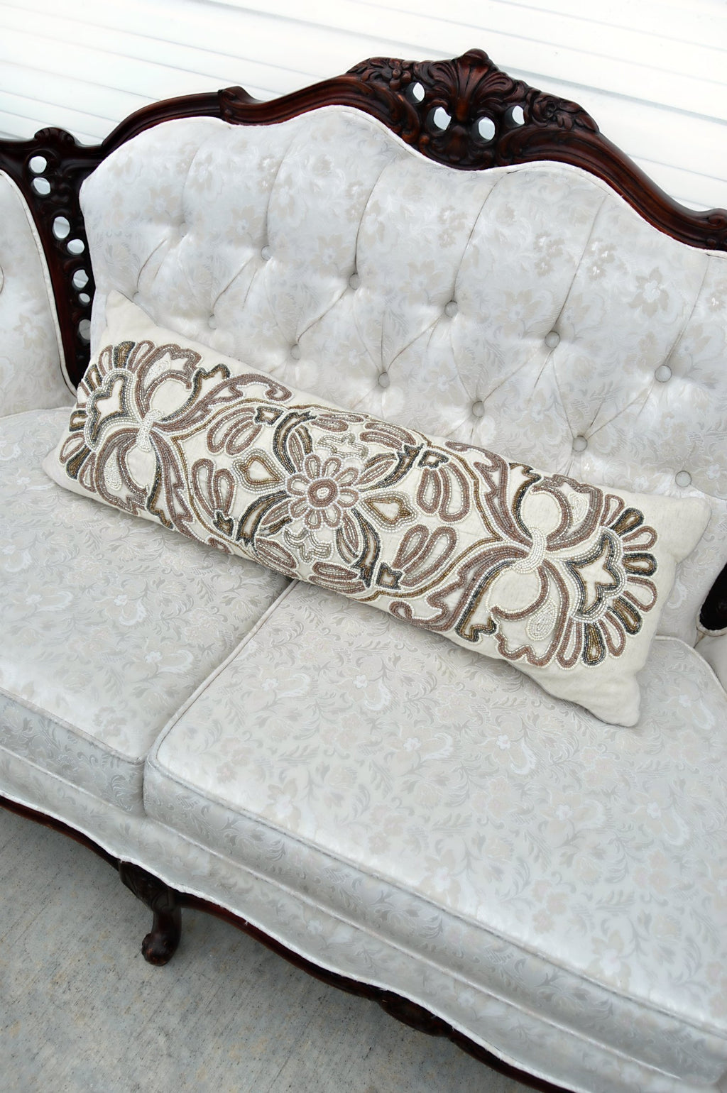 Ivory pillow with light purple, bronze, grey, and white beads