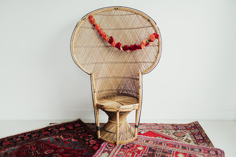 Wicker peacock chair with floral decor and boho rugs