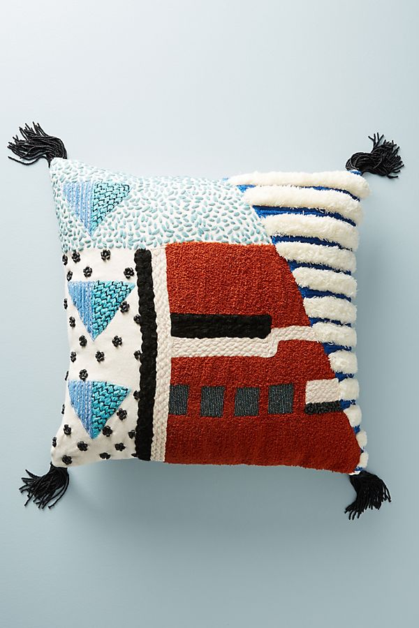 Geometric patterned pillow, blue and red with black tassels