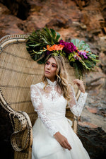 Bride sitting on boho peacock chair with bright florals