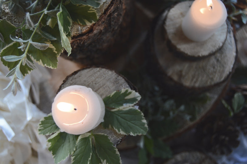 Sliced wood centerpieces with candles and greenery