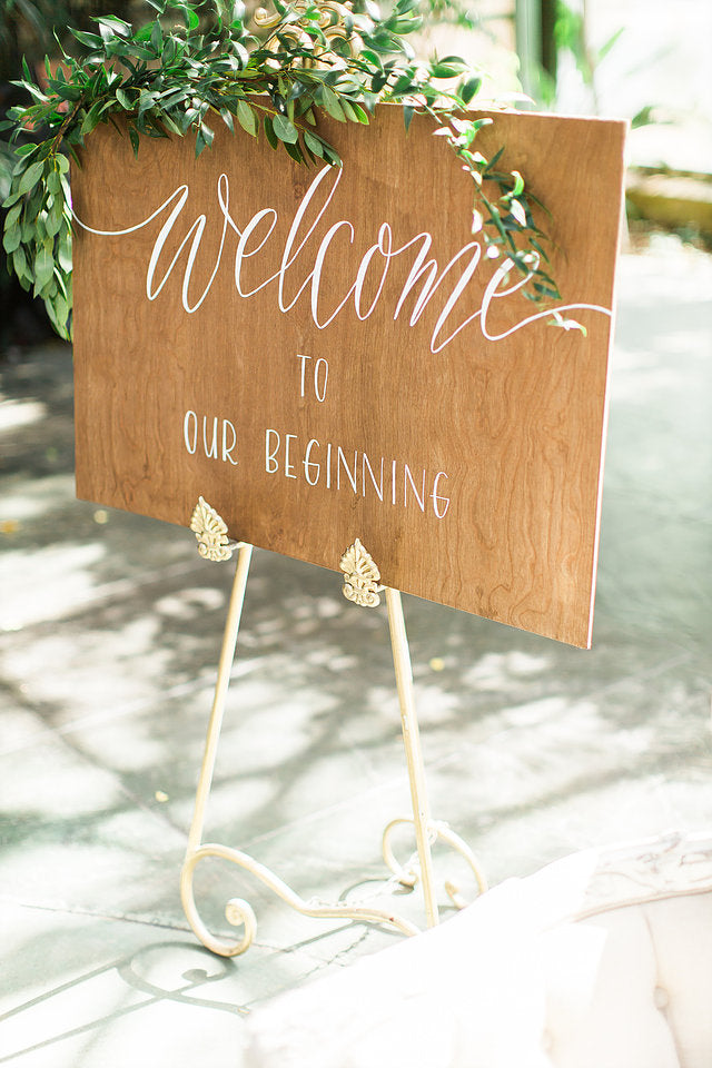 "Welcome to our Beginning" wooden wedding sign on easel