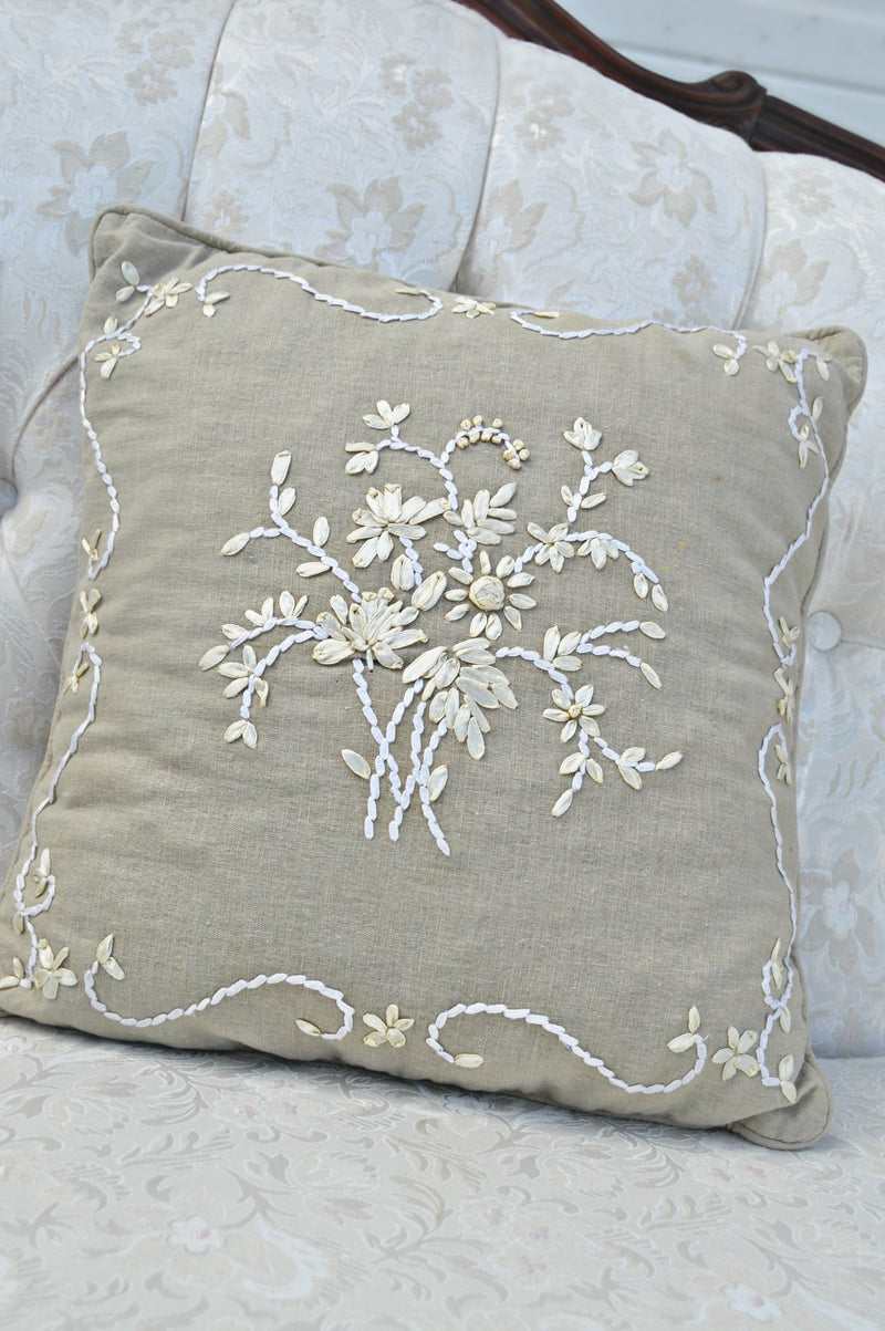 Tan pillow with ivory patterned ribbon embroidery