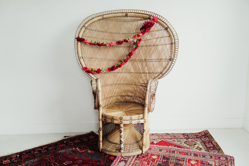 Wicker peacock chair with floral decor and boho rugs