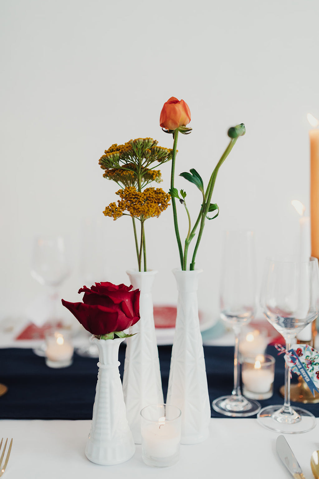 White milk glass vases with florals as centerpieces